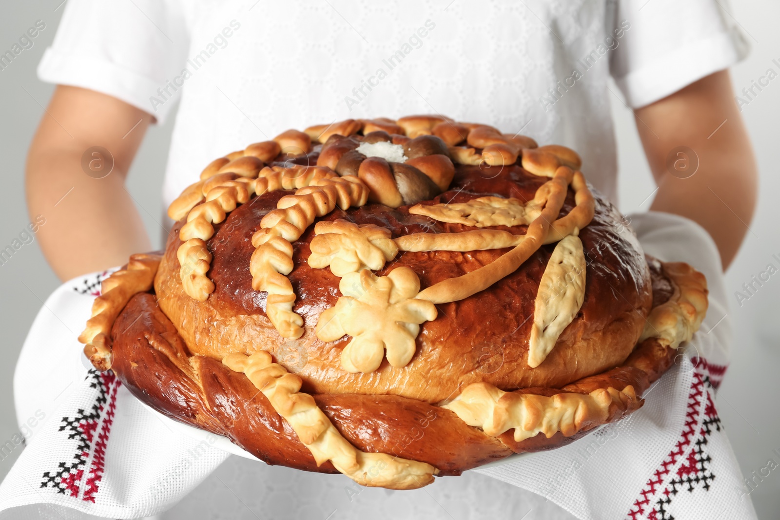 Photo of Woman with korovai, closeup. Ukrainian bread and salt welcoming tradition