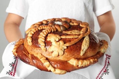 Photo of Woman with korovai, closeup. Ukrainian bread and salt welcoming tradition