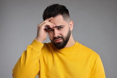 Photo of Portrait of sad man on light grey background