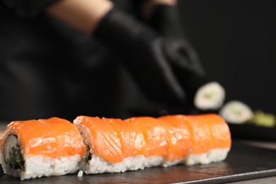 Photo of Tasty sushi rolls with salmon, cream cheese and cucumber on table, closeup