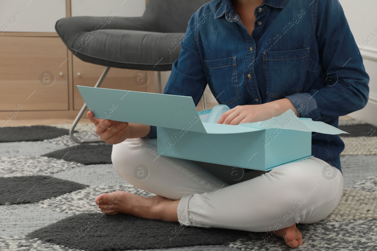 Photo of Woman with parcel on floor at home, closeup. Internet shopping