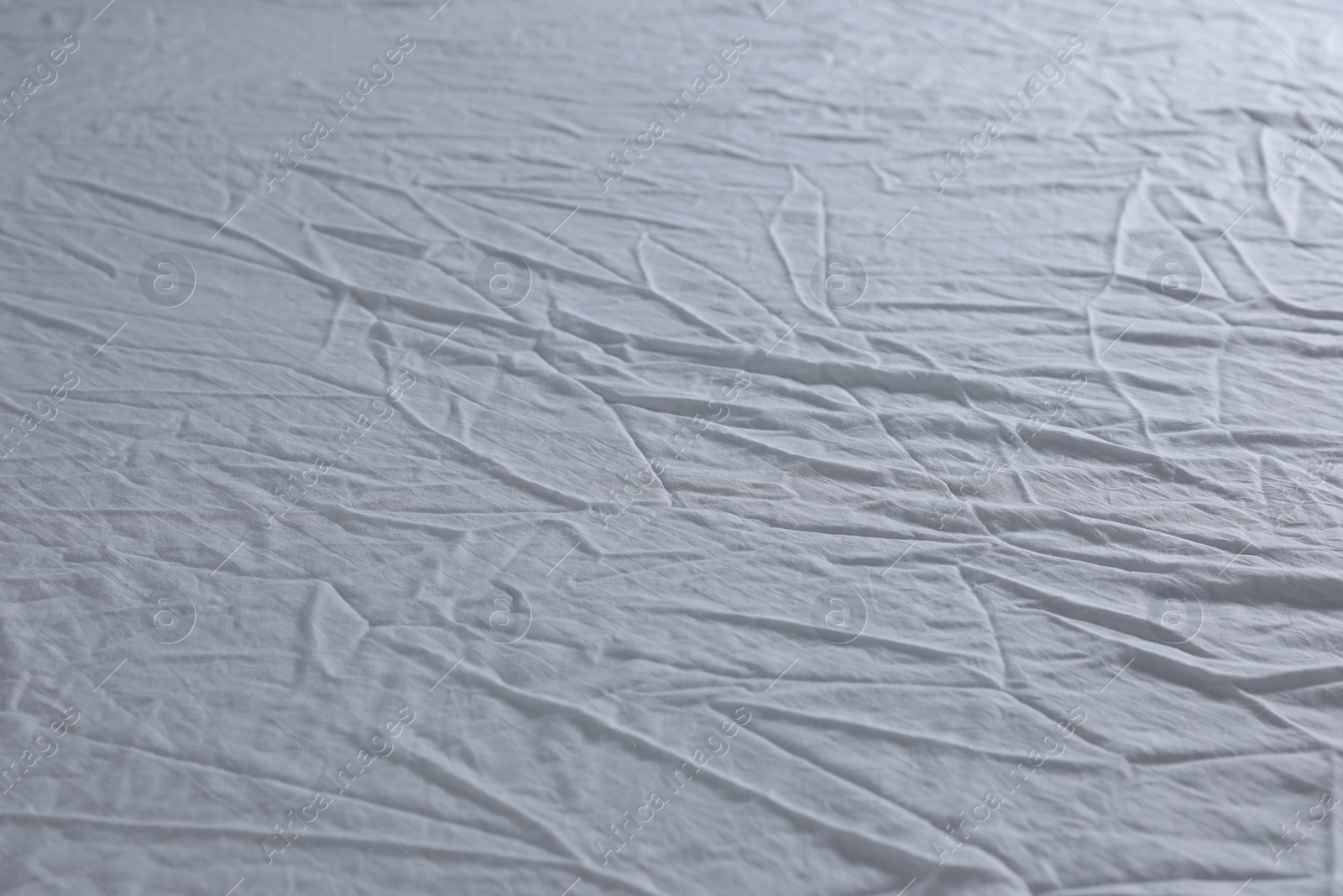 Photo of Crumpled white fabric as background, closeup view