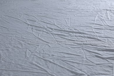 Photo of Crumpled white fabric as background, closeup view