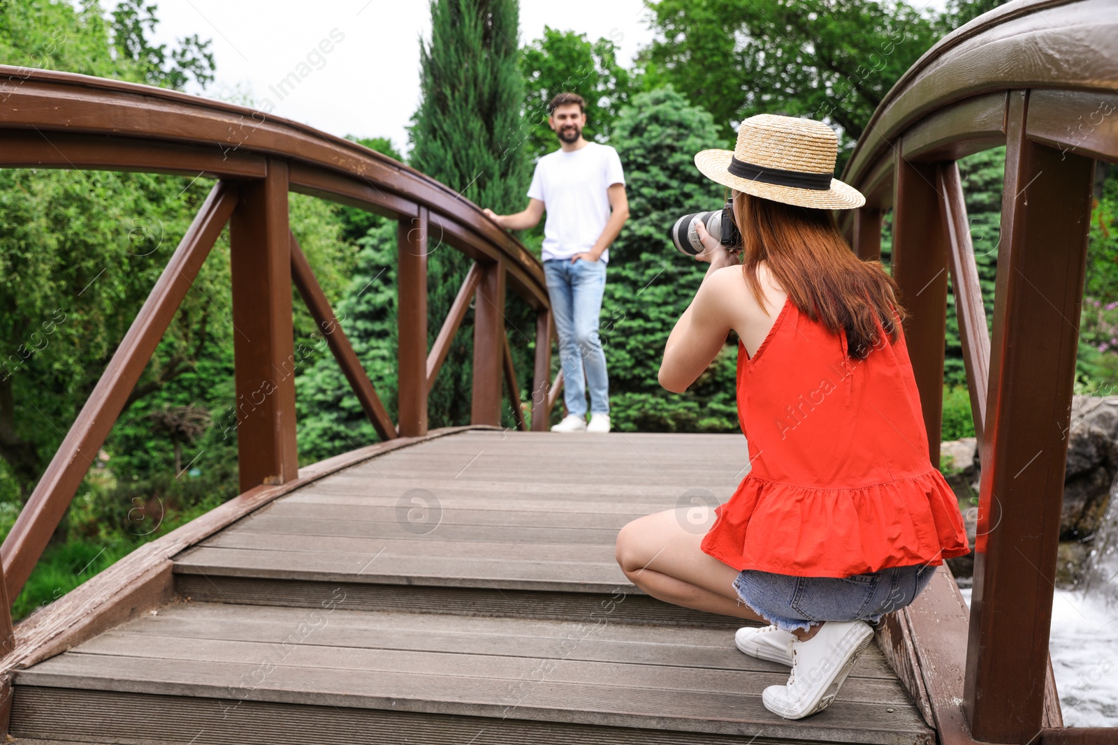 Photo of Photographer taking photo of man with professional camera in park