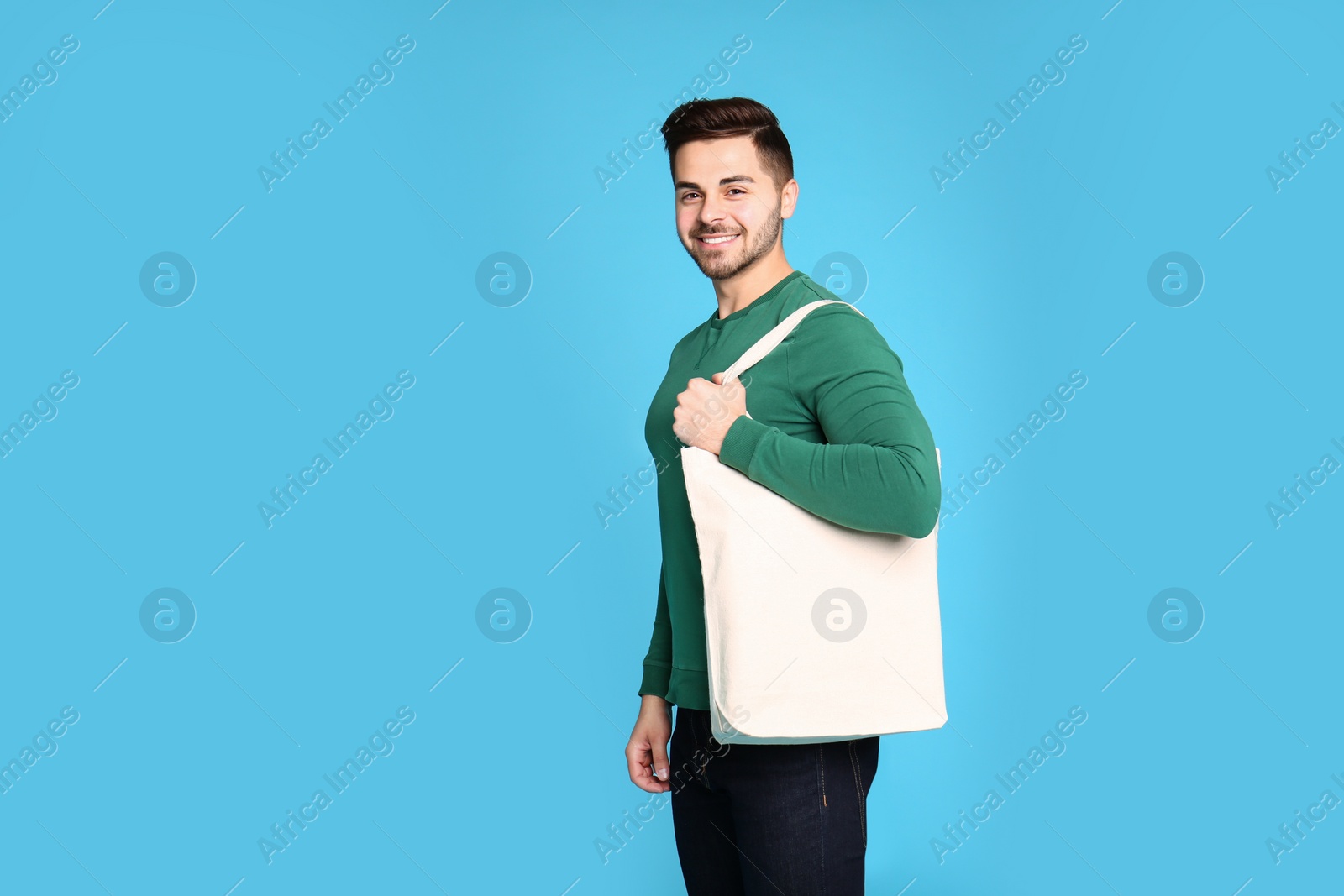 Photo of Portrait of young man with eco bag on blue background. Space for text