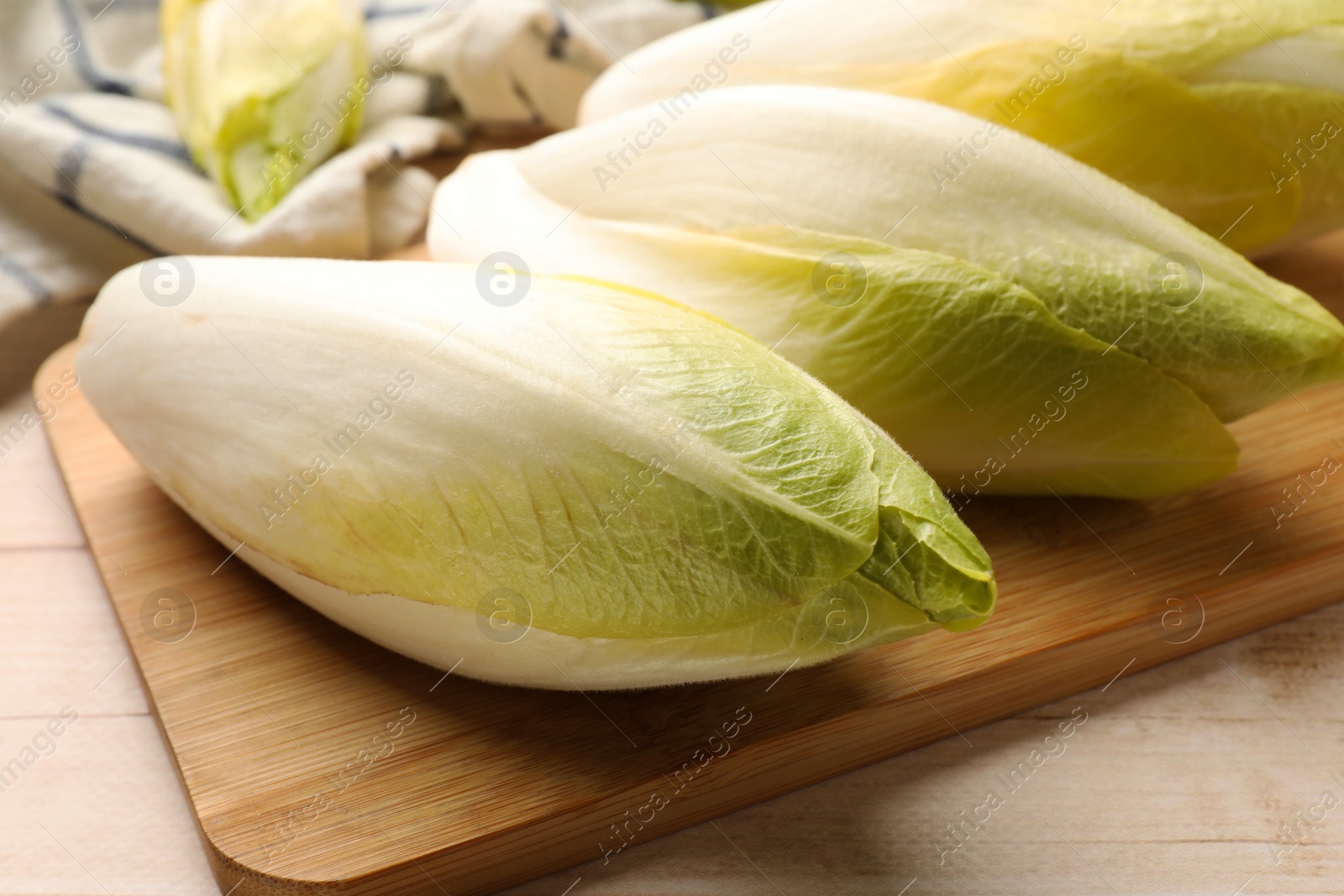 Photo of Raw ripe chicories on wooden table, closeup