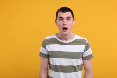 Photo of Portrait of surprised man on orange background