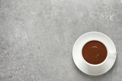 Photo of Yummy hot chocolate in cup on light grey table, top view. Space for text