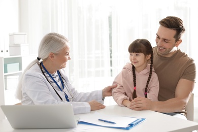 Photo of Father with child visiting doctor in hospital