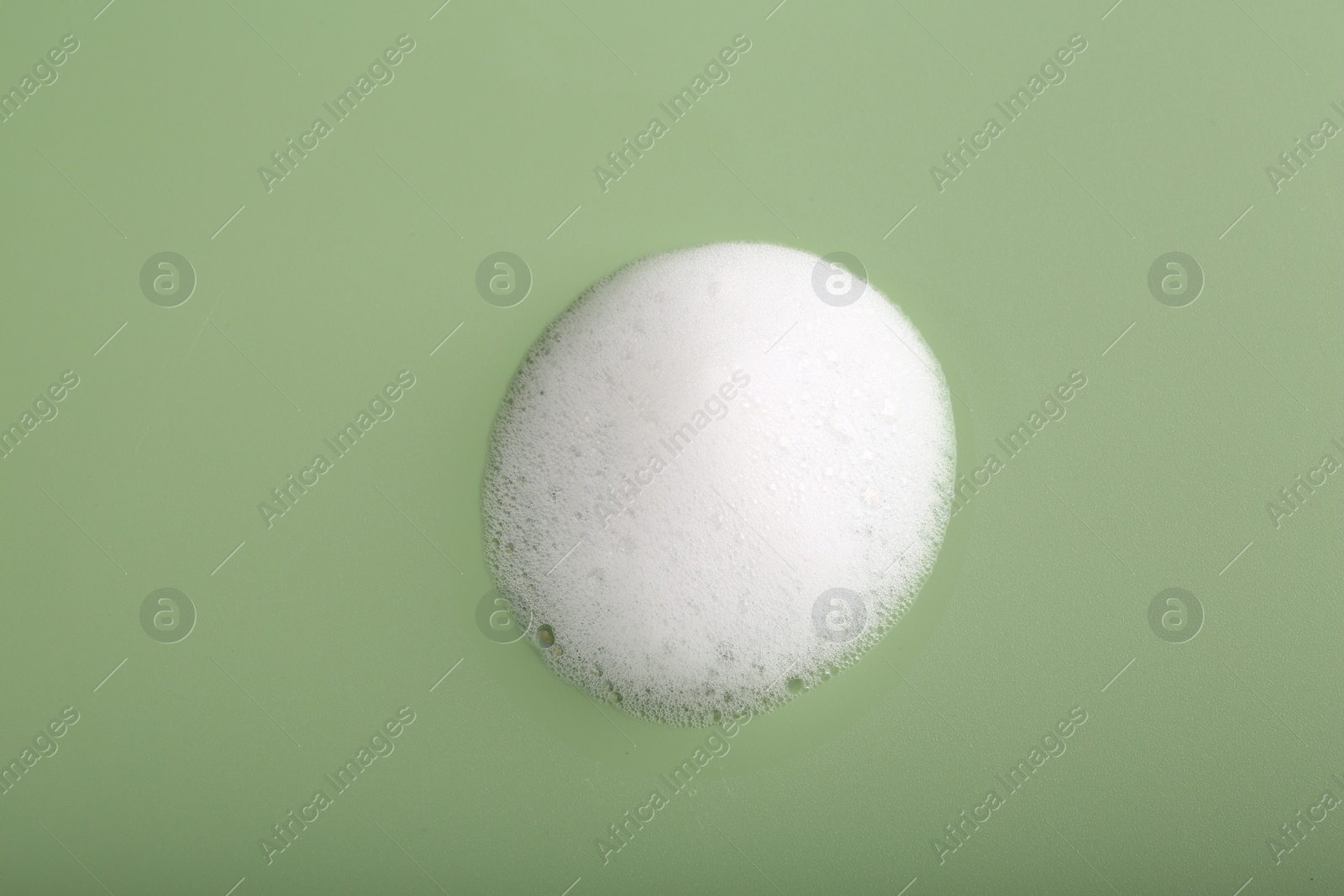 Photo of Sample of fluffy foam on green background, top view