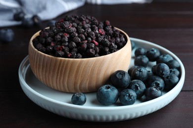 Freeze dried and fresh blueberries on wooden table, closeup