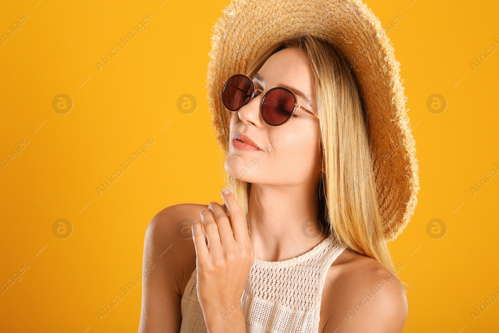 Photo of Beautiful woman in stylish sunglasses on yellow background