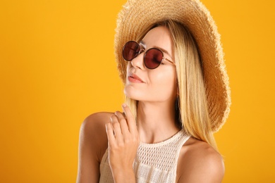 Photo of Beautiful woman in stylish sunglasses on yellow background