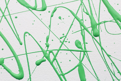 Photo of Green paint splashes on white canvas as background. Art and creativity