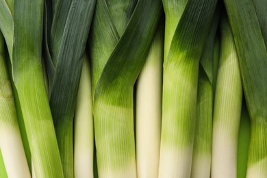 Fresh raw leeks as background, top view