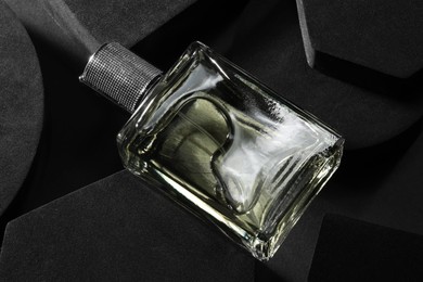 Photo of Stylish presentation of luxury men`s perfume in bottle on black background