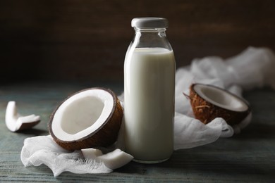 Bottle of coconut milk and nuts on wooden table