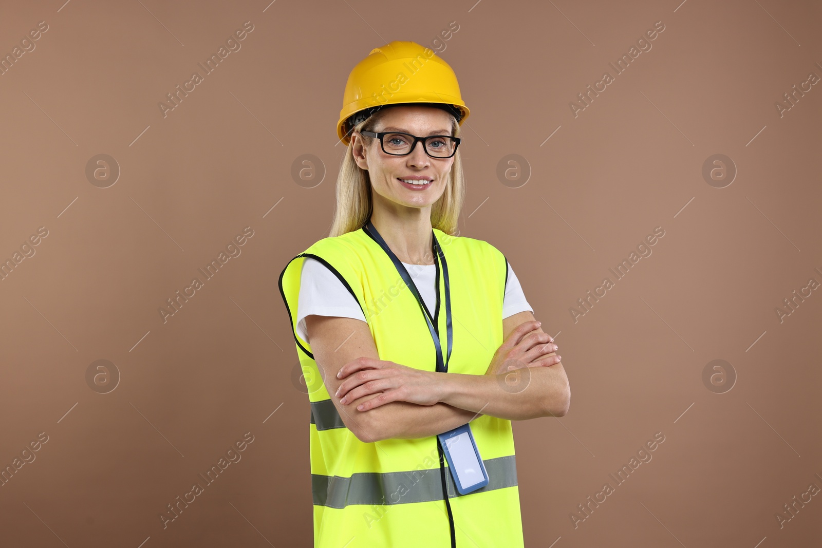 Photo of Engineer with hard hat and badge on brown background