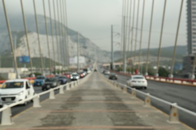 Photo of Blurred view of modern bridge with cars near city
