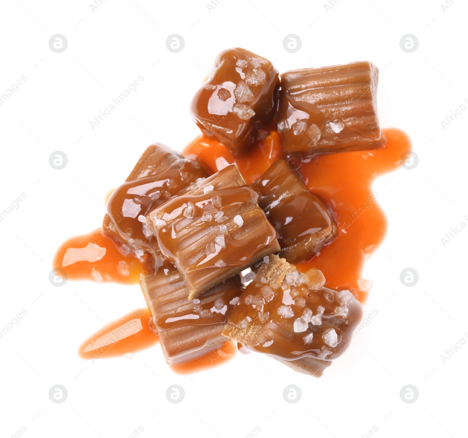 Photo of Delicious salted caramel with sauce on white background, top view