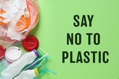 Image of Text SAY NO TO PLASTIC and disposable items on green background, flat lay