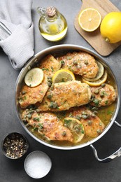 Delicious chicken piccata on grey table, flat lay