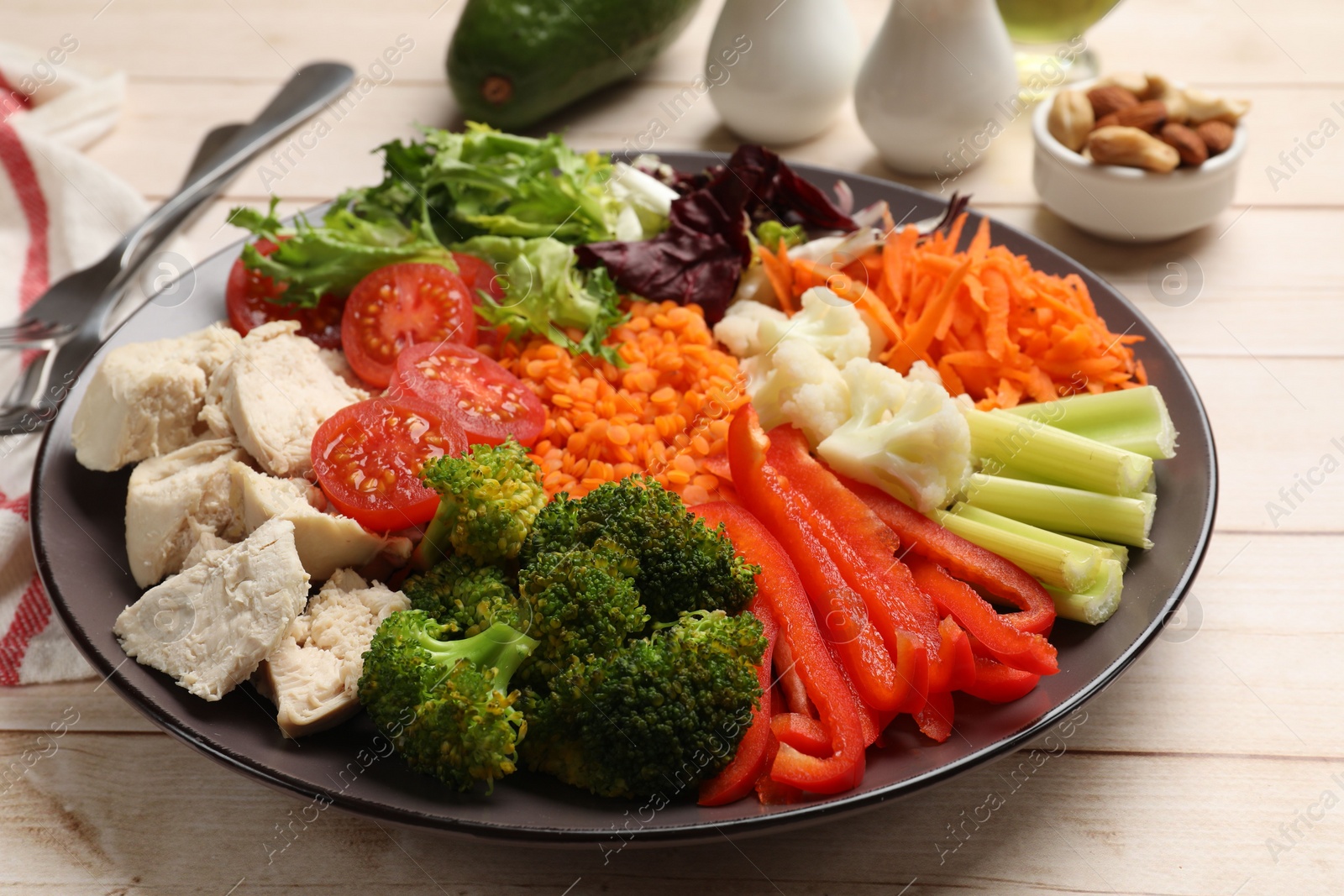 Photo of Balanced diet and healthy foods. Plate with different delicious products on light wooden table, closeup