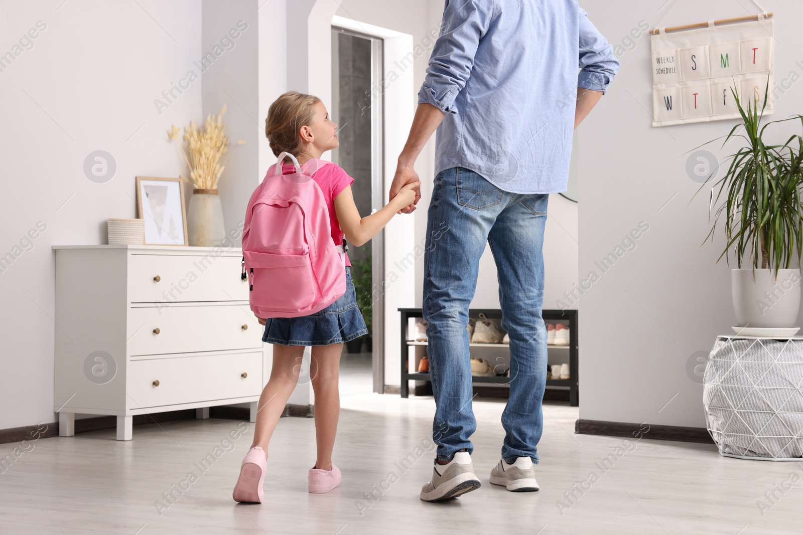 Photo of Little girl with father at home. Ready to go to school