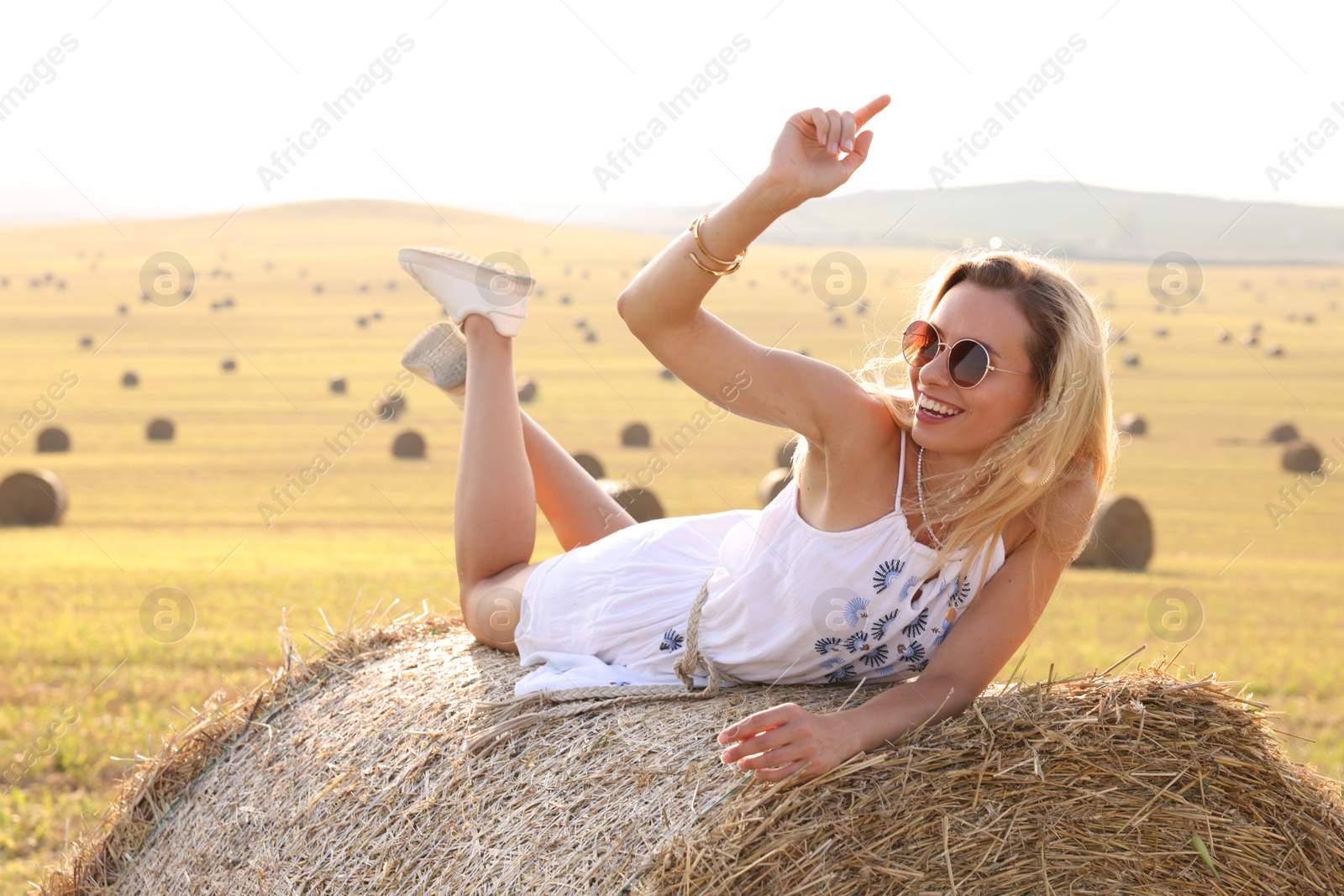 Photo of Beautiful hippie woman on hay bale in field