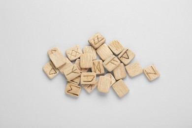 Pile of wooden runes on white background, flat lay