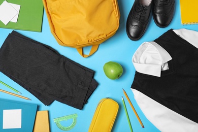 Photo of Flat lay composition with school uniform on blue background