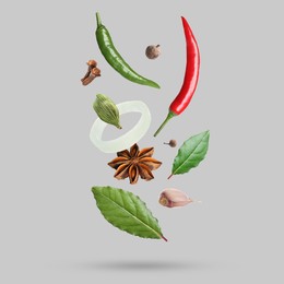 Image of Different spices falling on light grey background