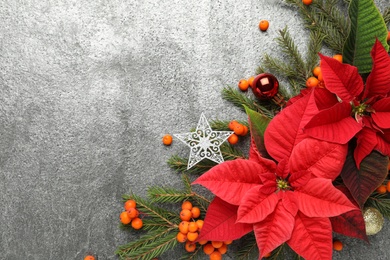 Photo of Flat lay composition with beautiful poinsettia on grey background, space for text. Christmas traditional flower