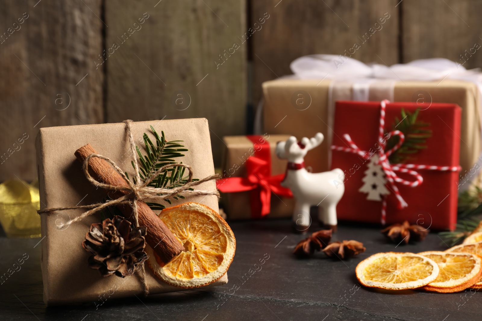 Photo of Beautiful gift box with Christmas decorations on black table. Space for text