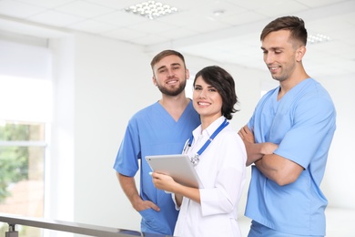 Photo of Team of doctors with tablet at workplace