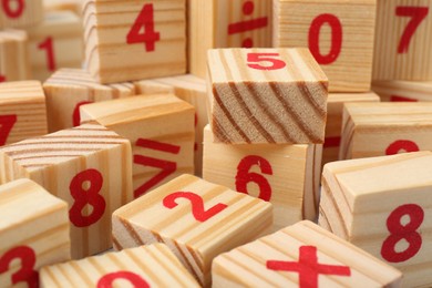 Wooden cubes with numbers and mathematical symbols, closeup