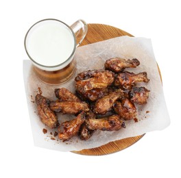 Photo of Tasty chicken wings and mug of beer isolated on white, top view. Delicious snack