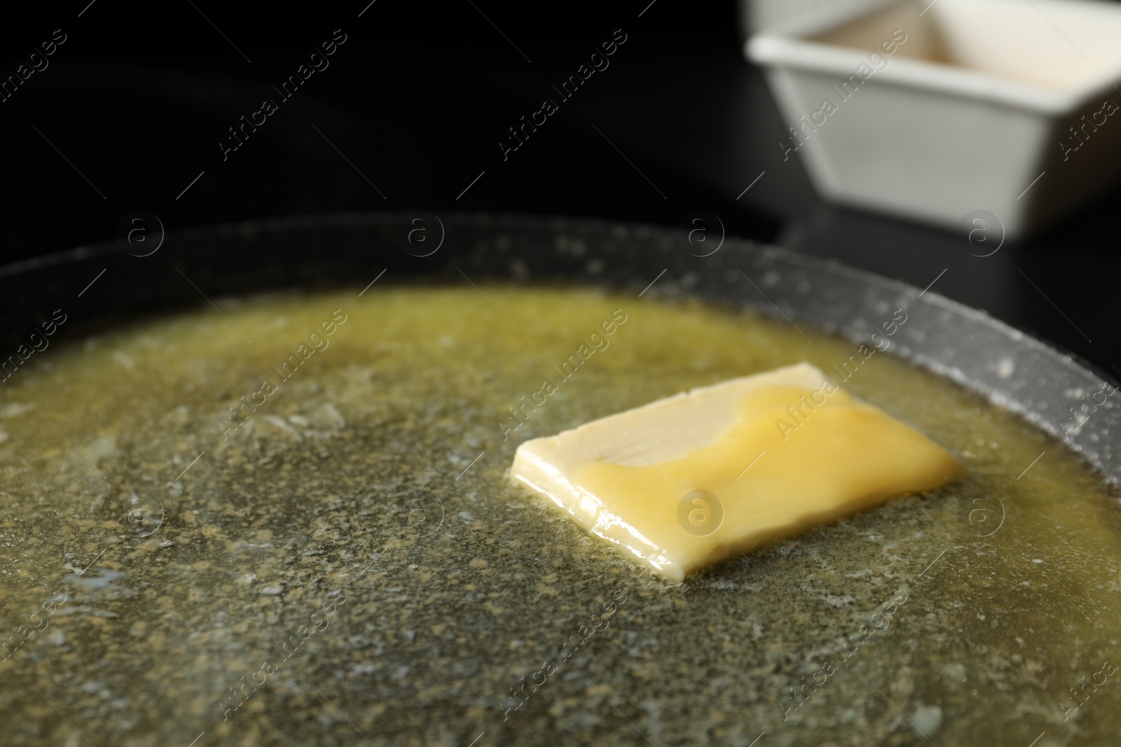 Photo of Melting butter in frying pan on table, closeup