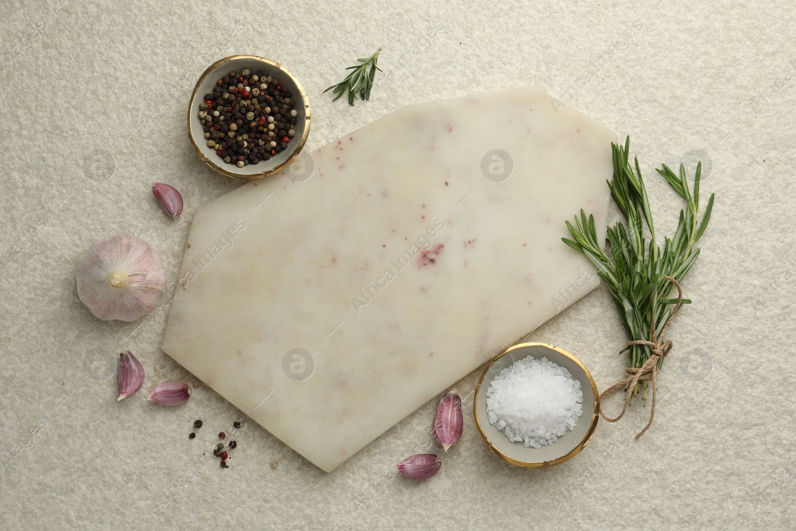 Photo of Cutting board, salt, pepper, rosemary and garlic on white textured table, flat lay. Space for text