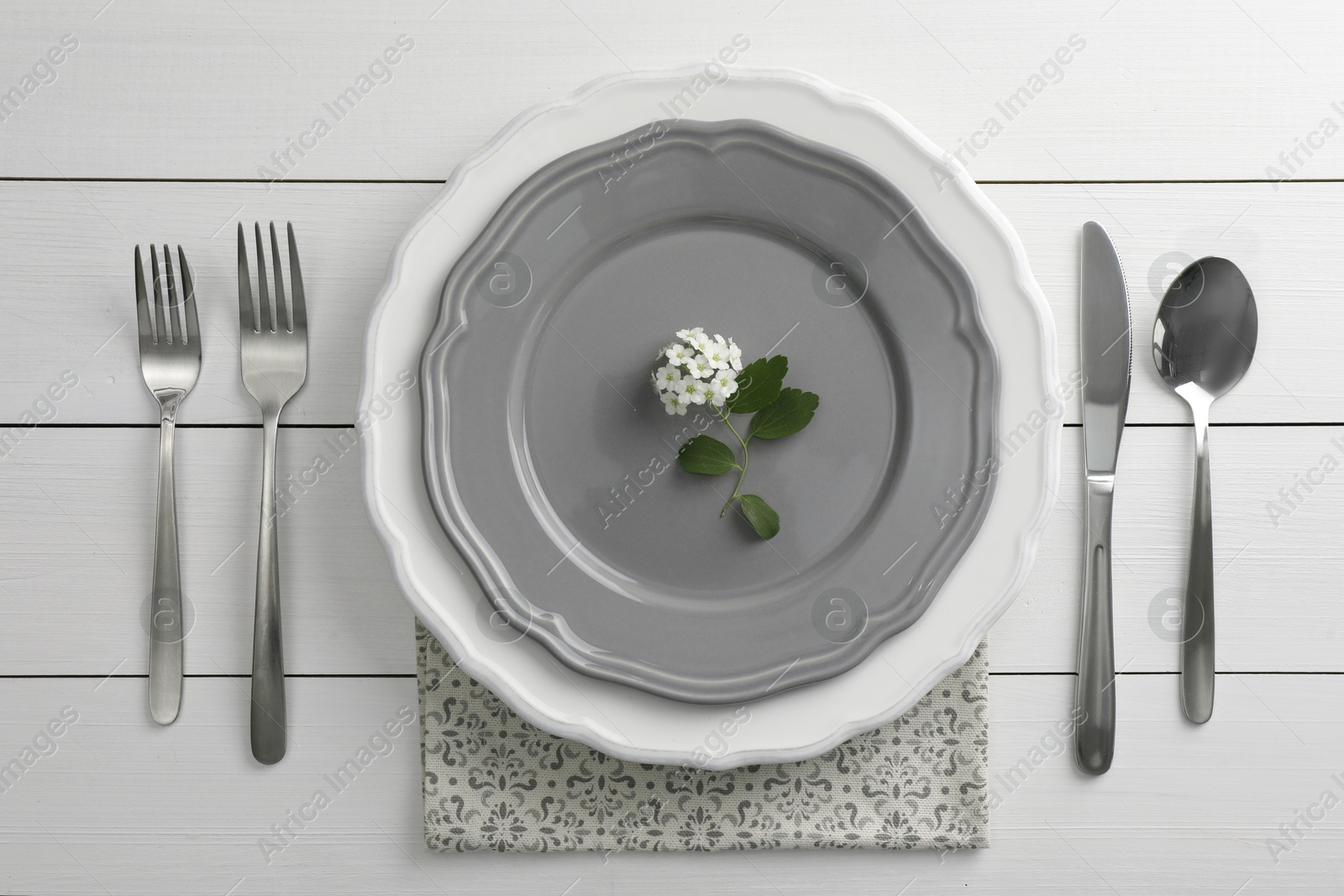 Photo of Stylish setting with cutlery and plates on white wooden table, flat lay