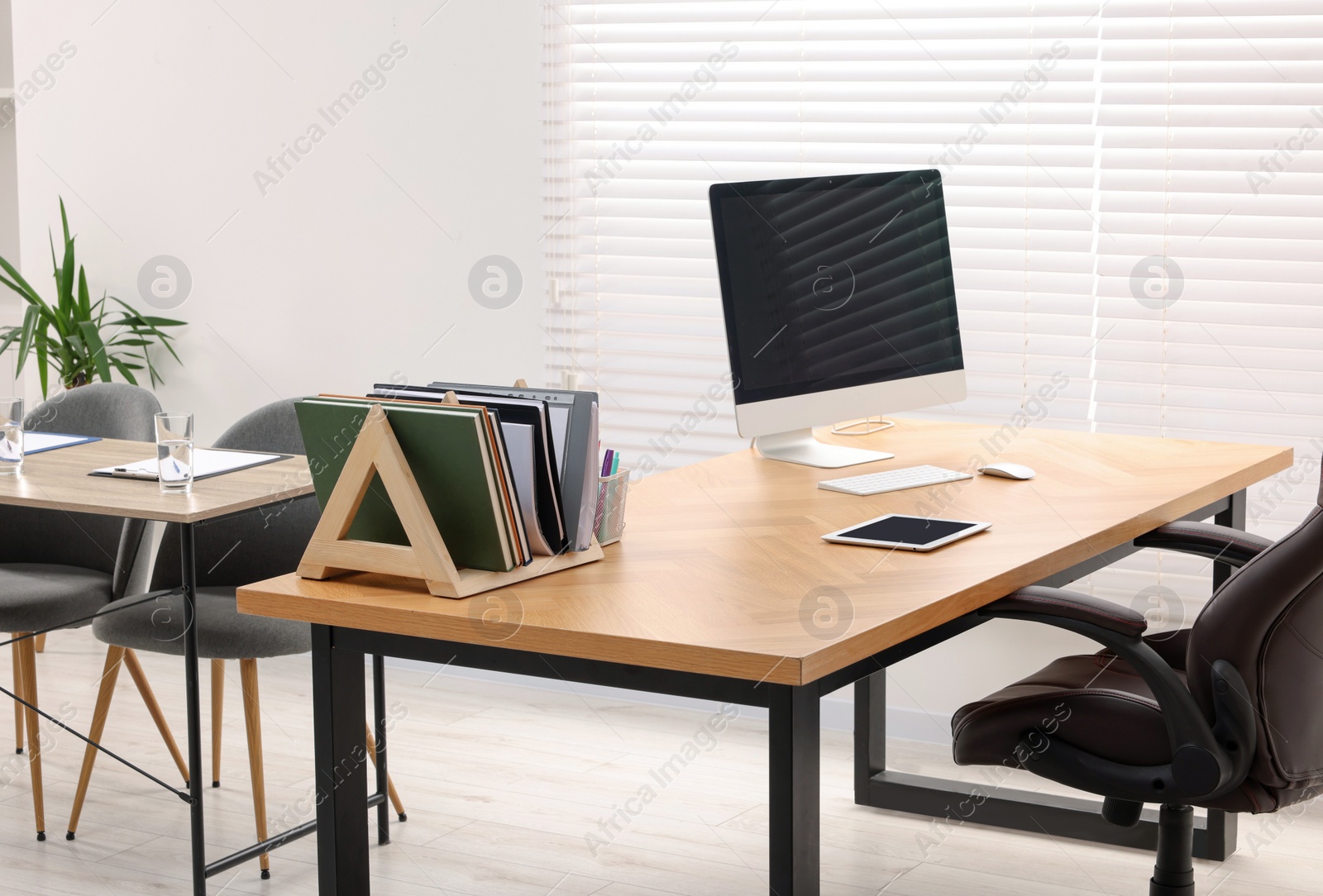 Photo of Director's office with large wooden table and comfortable armchairs. Interior design