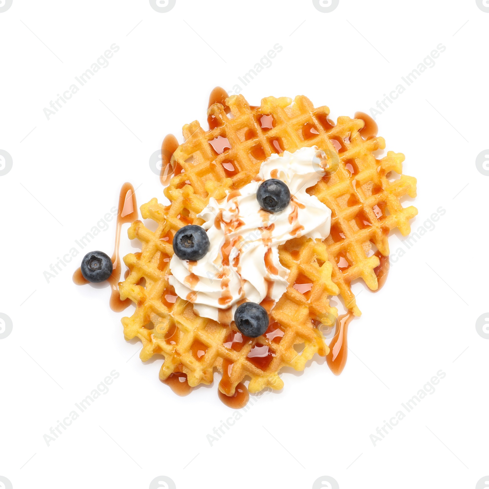 Photo of Delicious waffles with caramel syrup, whipped cream and blueberries on white background, top view