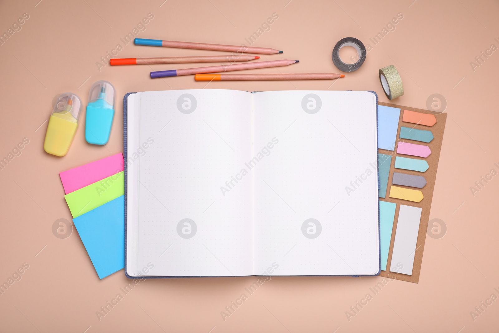 Photo of Open planner and stationery on beige background, flat lay. Space for text