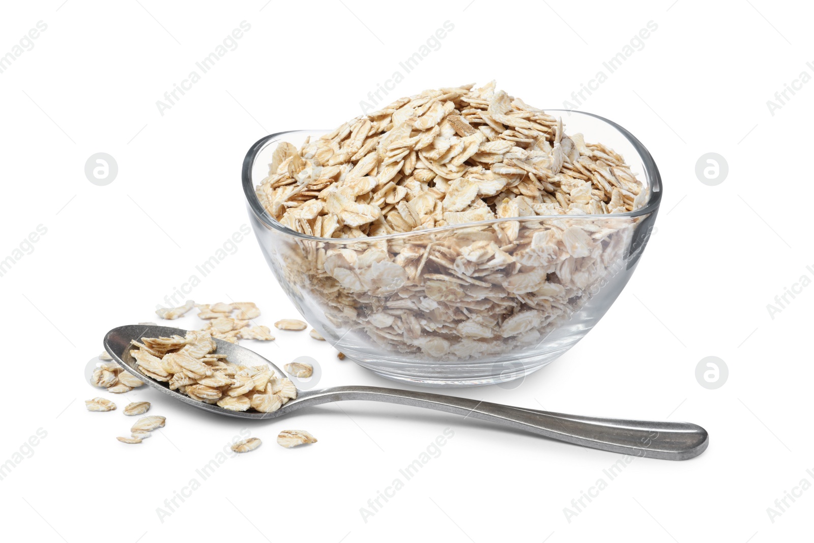 Photo of Raw oatmeal, glass bowl and spoon on white background