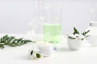 Photo of Skin care product, ingredients and laboratory glassware on table. Dermatology research