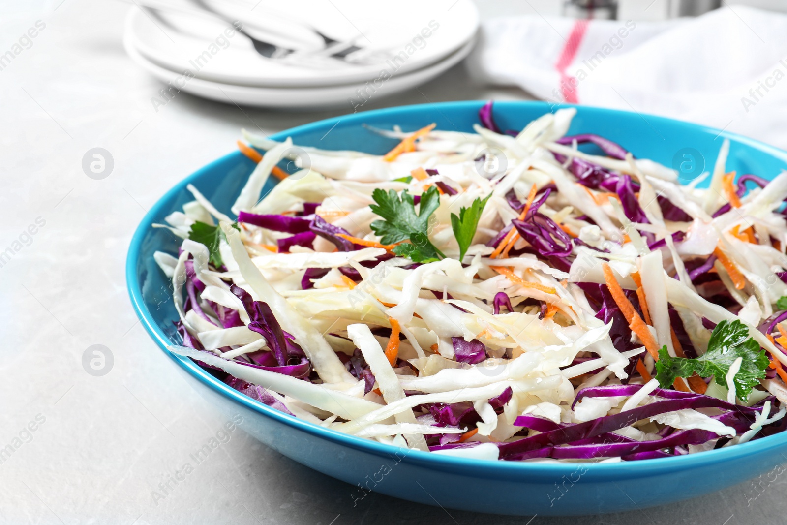 Photo of Tasty salad with cabbage on light grey marble table, closeup