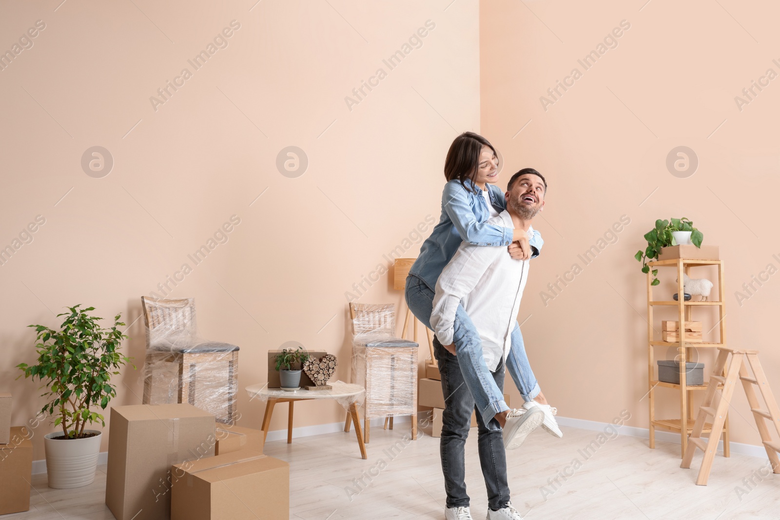 Photo of Happy couple having fun in new apartment. Moving day