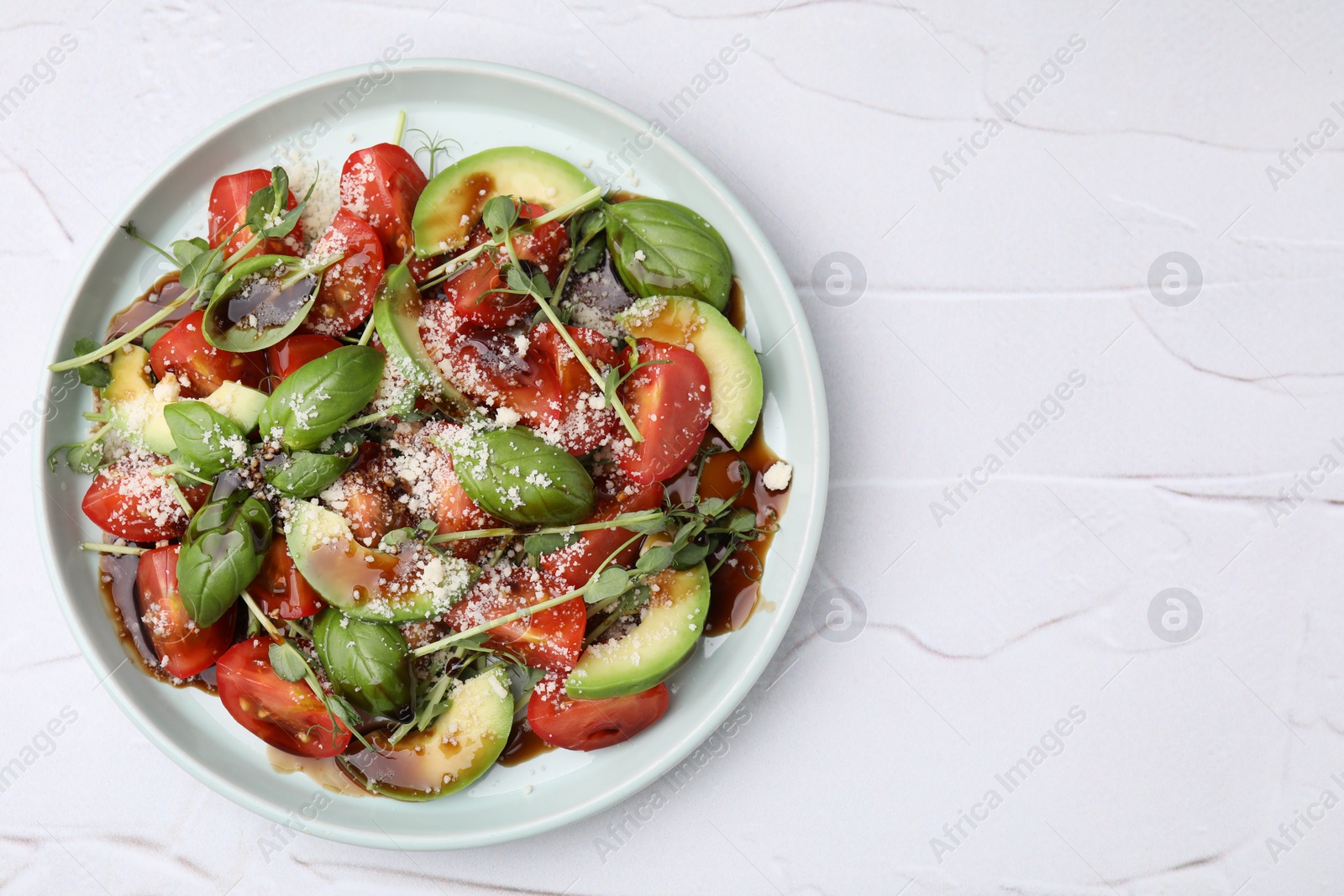 Photo of Tasty salad with balsamic vinegar on white textured table, top view. Space for text