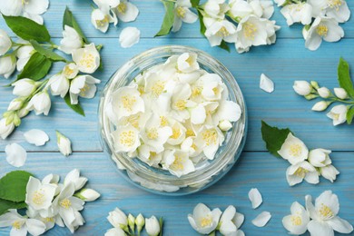 Photo of Flat lay composition with beautiful jasmine flowers on light blue wooden background