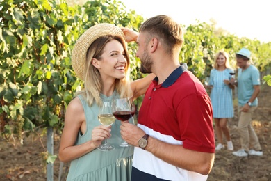 Romantic couple holding glasses of wine at vineyard